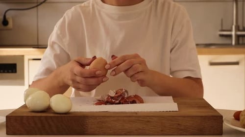 Woman Peeling Boiled Egg on Wooden Cutting Board