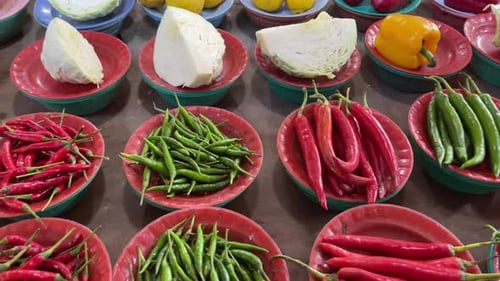Array of fresh vegetables and fruits produce displayed at the local market. Red and green chillies,