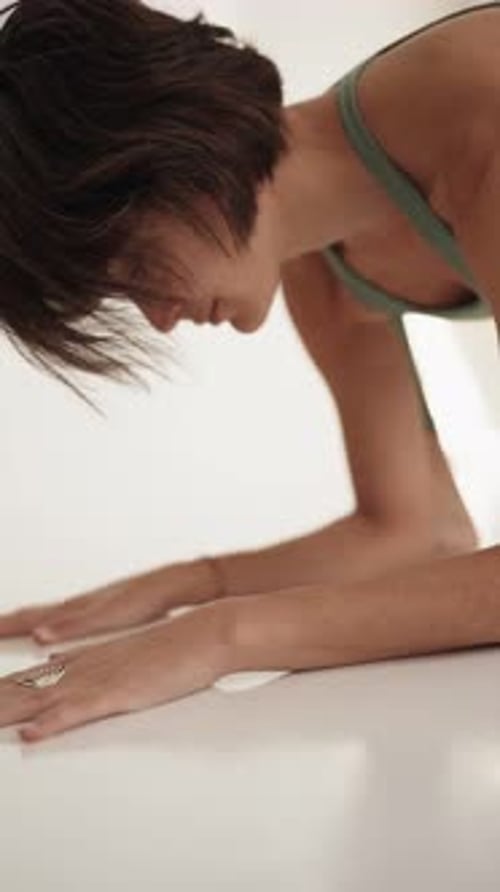 Young Woman Doing Yoga Stretch in Studio