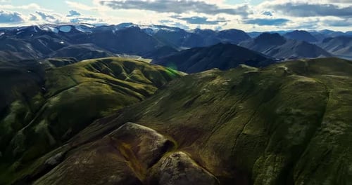 Breathtaking Aerial View of Sunlit Mossy Volcanic Mountains in Iceland