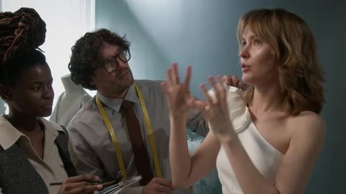 Young Woman Discussing Wedding Dress Design with Bridal Shop Workers