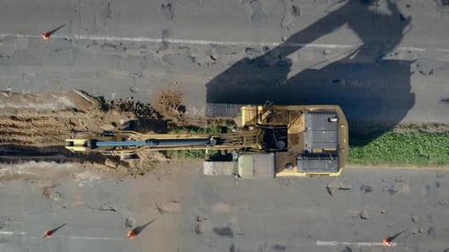 Large Crawler Excavator Digs Ground and Performs Major Repairs of Paved Road