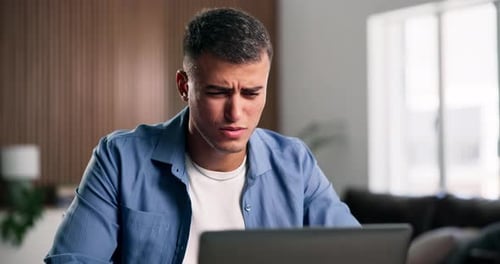 Man Looking Worried While Working on Laptop