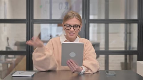 Young Woman Doing Video Chat on Tablet in Office