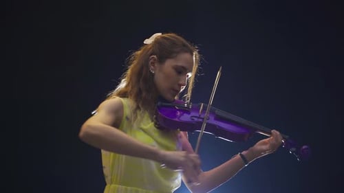 Woman Plays Purple Violin in Studio Setting