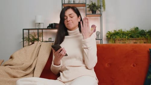 Woman Using Smartphone On Couch At Home