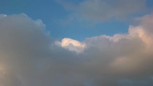 Zeitraffer von dunklen und weißen Wolken auf blauem Himmelshintergrund.