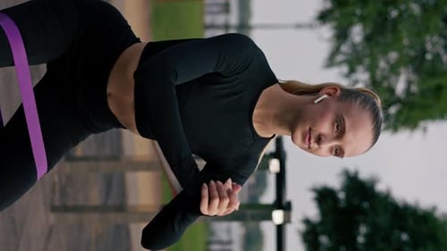Woman Exercises Outdoors with Resistance Band