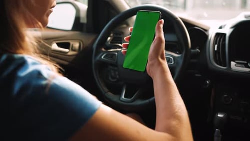 Female Driver Using a Smartphone Inside the Car Chromakey Smartphone with Green