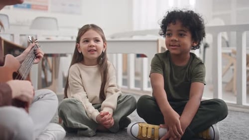 Teacher Plays Ukulele for Children in Classroom