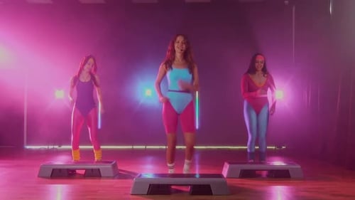 Women doing step aerobics in colorful 80s attire