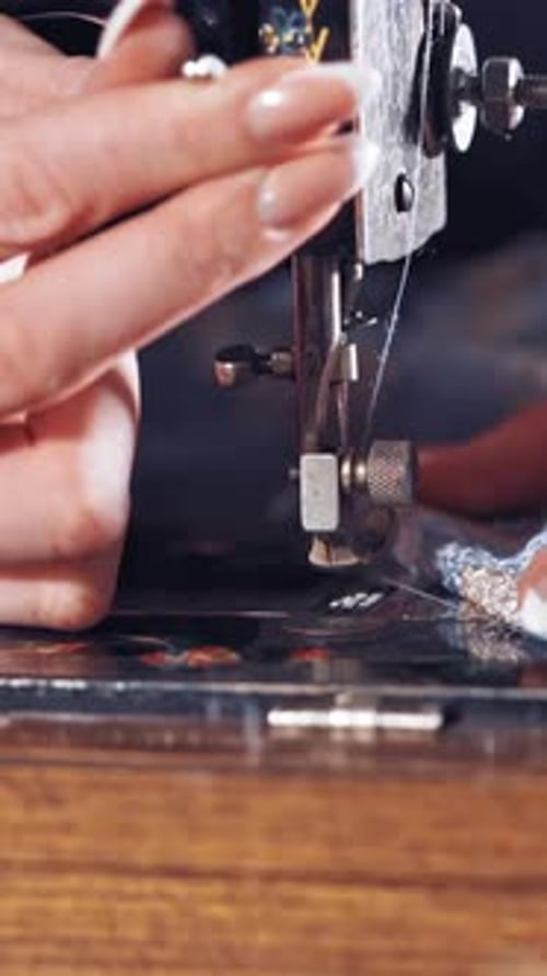 Die
Näherin näht Kleidung maschinell. Nahaufnahme von Nähmaschine und Kleidungsstück