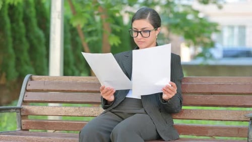 Indian Businesswoman Reviewing Documents in Park