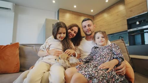 Happy Family Poses With Dog on Couch