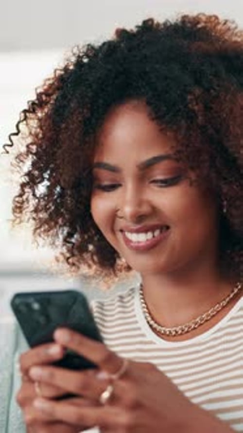 Smiling Woman Using Smartphone in Home Interior