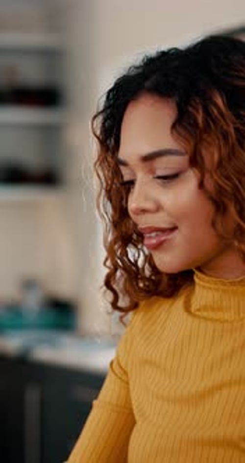 Woman Smiling While Typing on Laptop Indoors