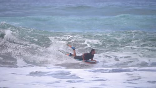 Surfer ride waves in slow motion at Las Canteras beach in Las Palmas de Gran Canaria, Spain.