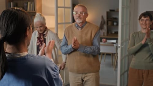 Seniors Exercise with Young Adult Healthcare Worker at Home