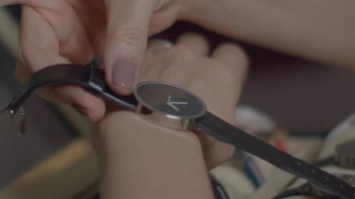 Woman Fastening Watch on Wrist Close Up