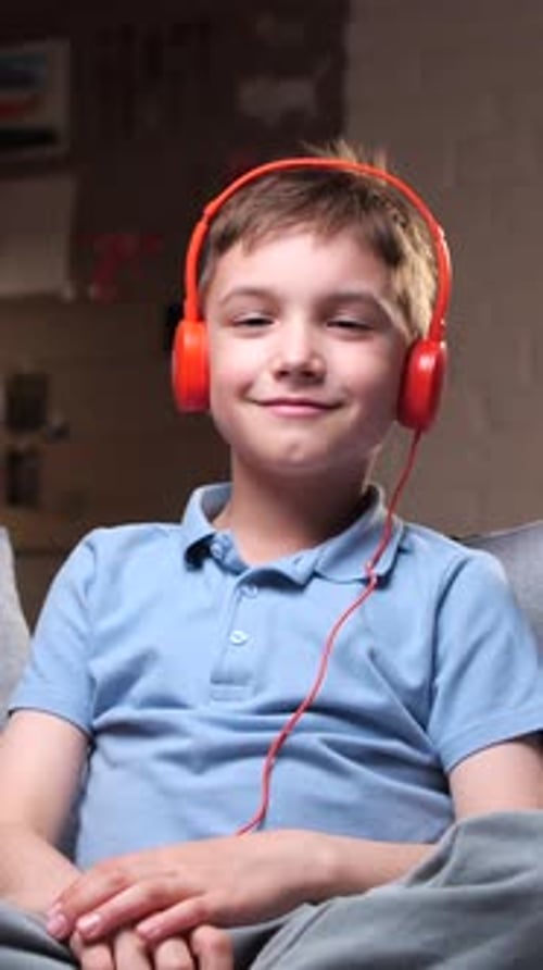 Boy Putting on Bright Red Headphones at Home