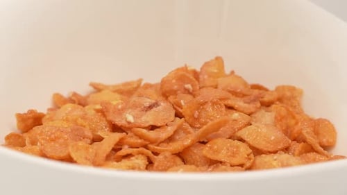 Cornflakes Pouring into White Bowl Close-Up