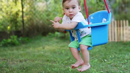 Adorable Infant Relaxing in a Backyard Swing