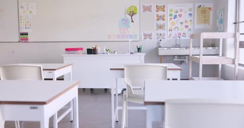 Empty, classroom and interior of school in education with whiteboard, desk and chairs in morning