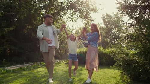 Family walking on sunny lawn together outside home