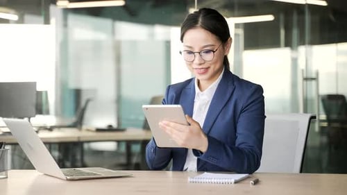Young Woman Working on Tablet in Modern Office