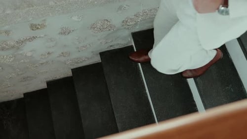 Man in Light Suit Descends Stone Staircase