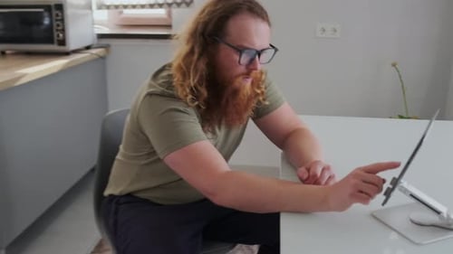 Man With Beard Using Tablet at Table