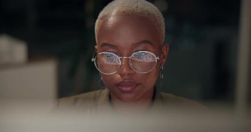 Computer, glasses and web design with developer woman in office at night for coding or programming