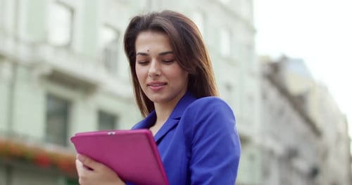 Close Up of Pretty Young Caucasian Brunette Woman Standing at City Street with Tablet Device and