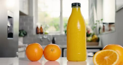 Nutrition, jus ou bouteille dans la cuisine avec des bienfaits de l'orange, des antioxydants ou des vitamines dans la boisson du matin