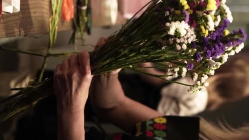 Florist Crafting Bouquet. Florist at Work. Florist makes bouquet in flower shop in Lviv Vertical