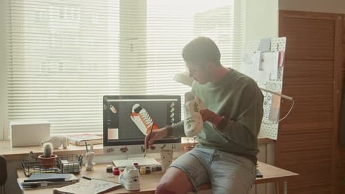 Focused Man Working on Colorful Design of Sneakers in Loft Studio