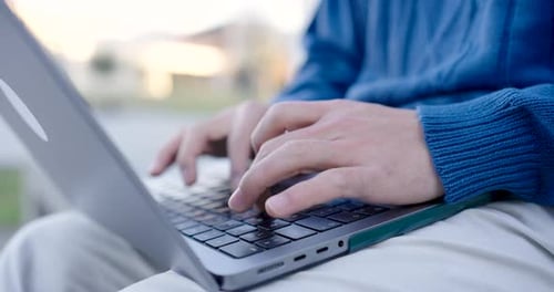 Crop Man tapant sur le clavier d'un ordinateur portable pendant la journée