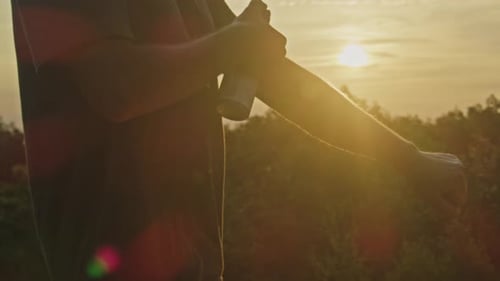 Man Sprays Mosquito Repellent on Mountain at Twilight