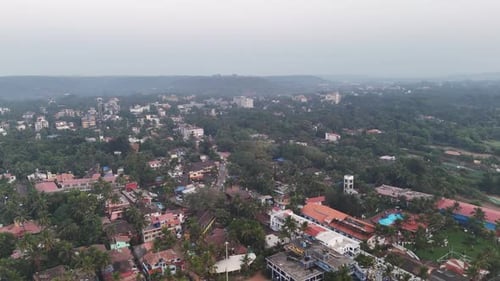 Grande vue aérienne cinématographique de Calangute mettant en valeur un hôtel de luxe au cœur d'un environnement luxuriant, avec