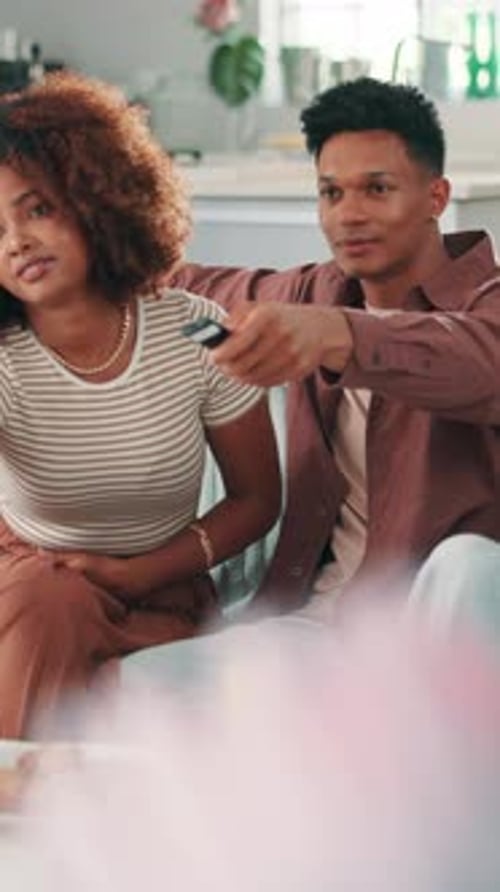 Young Couple Relaxing on Couch Watching TV