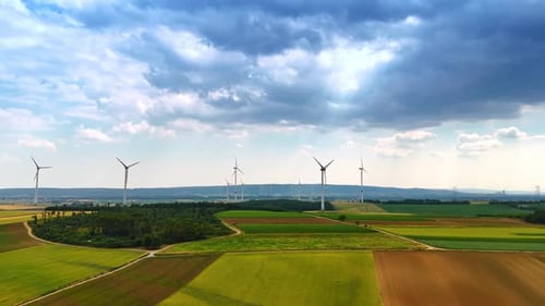 Windturbinen auf grünen Feldern. Weite grüne Felder mit sich drehenden Windrädern