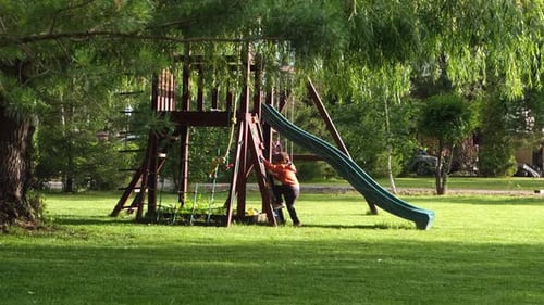 Playground for Kids in a Park Baby Boy Toddler Having Fun and Playing on the Slide Playhouse and