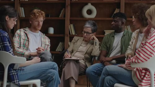 Group of Diverse Adults Talking in Circle During Therapy Session