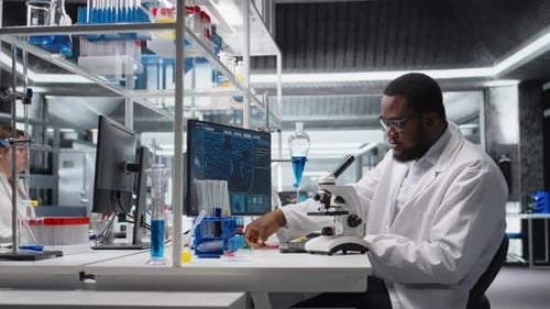 Scientist Adjusting Microscope in Modern Lab