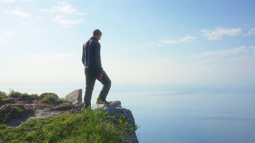 Man Enoy Nature and Open Arms on the Sea Cliff at Day