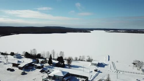 Cold sunny blue sky winter day at a frozen lake in the northern countryside of Canada - Drone 4k Aer