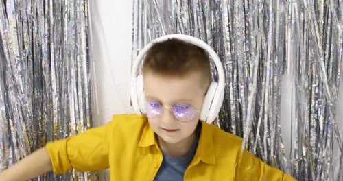 Enthusiastic Boy Dances with Headphones and Yellow Shirt