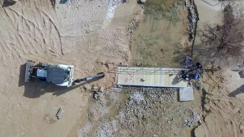 Weißer Traktor bewegt Strandsand - Luftaufnahmen von oben nach unten.