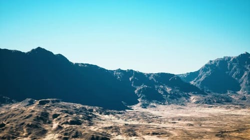 Sundrenched Mountain Gorge with Shadowed Ridges and Clear Sky