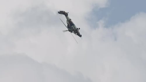 Military Helicopter Flying Through Cloudy Sky
